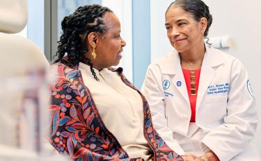 MSK’s Dr. Carol Brown smiles with a patient and warmly holds her hand.
