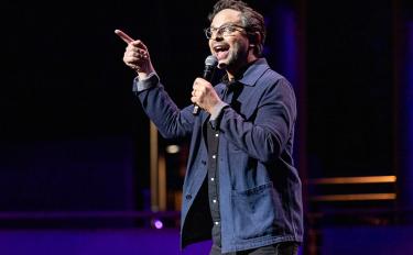 Comedian Nick Kroll standing onstage as host of Comedy vs Cancer, MSK’s fundraising event for blood cancer research 